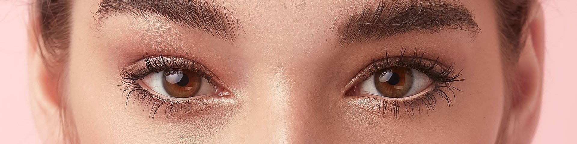 A close-up on a woman's eyes. They are brown and her make up is subtle shades of gold. She has fashionably natural eyebrows.
